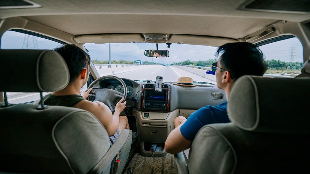 Asian Chinese Gay couple travelling using mobile app road map with campervan for vacation road trip during weekend